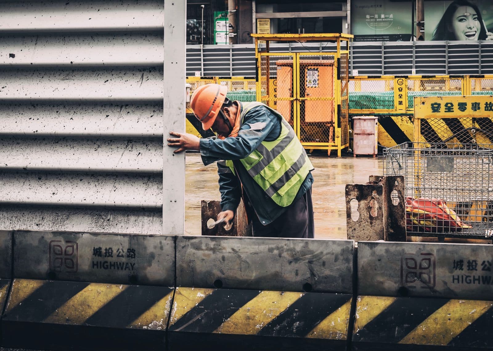 Handwerker in Warnweste und Helm bei der Arbeit an der Straße